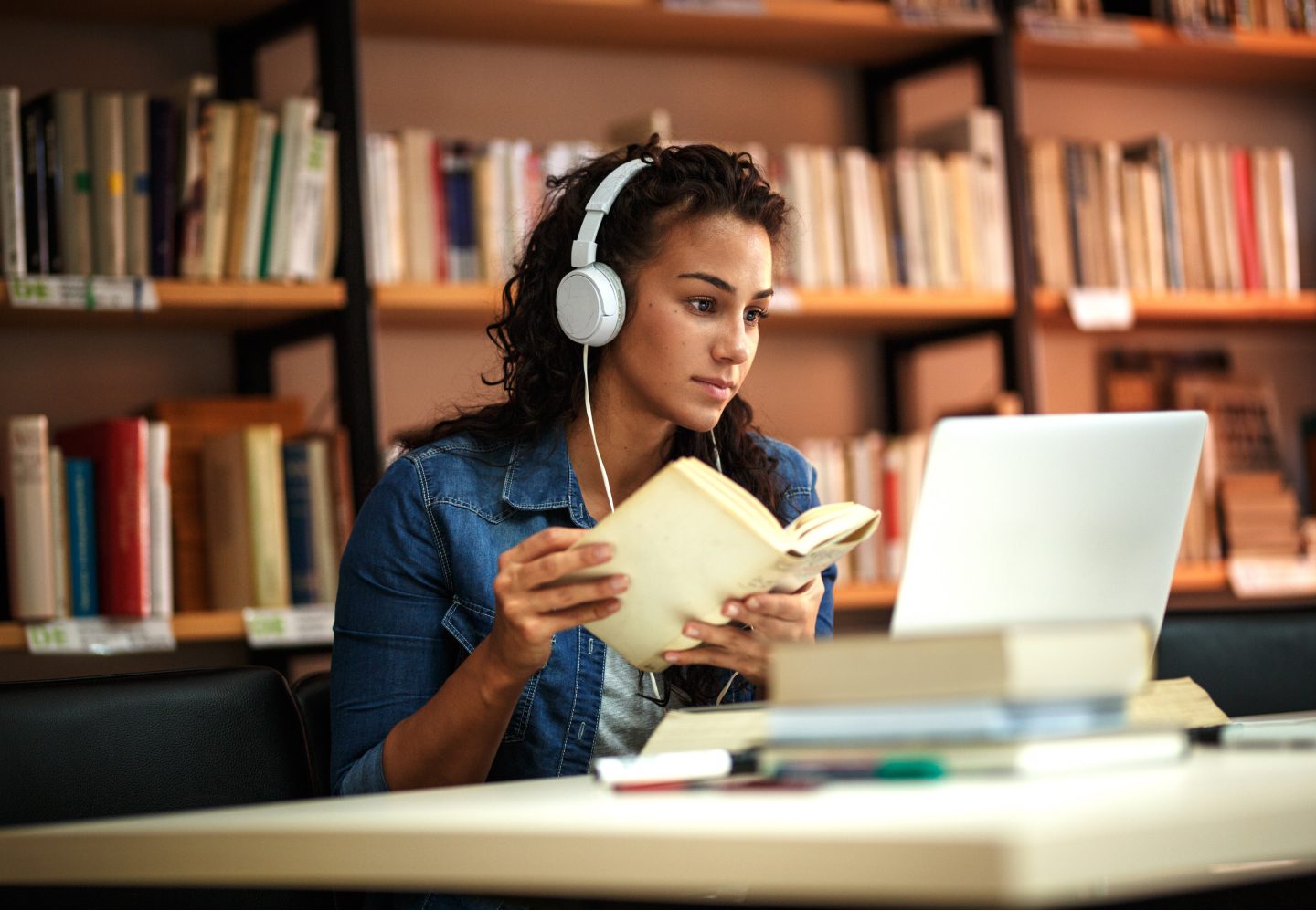 Close up of a student studying on a laptop at the library