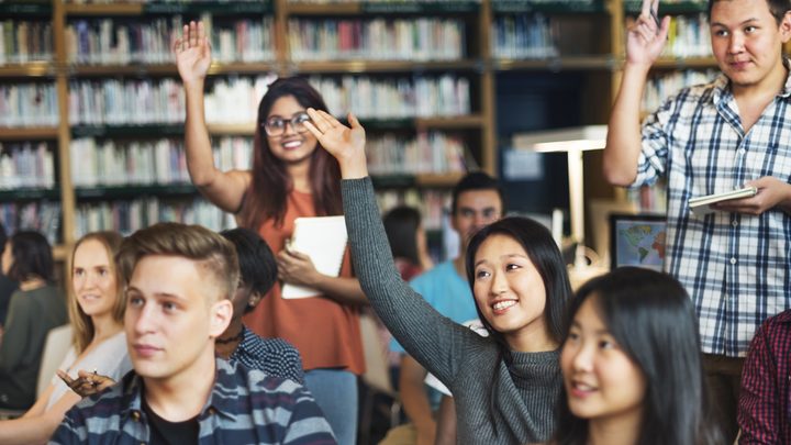 Students raising their hands to ask questions